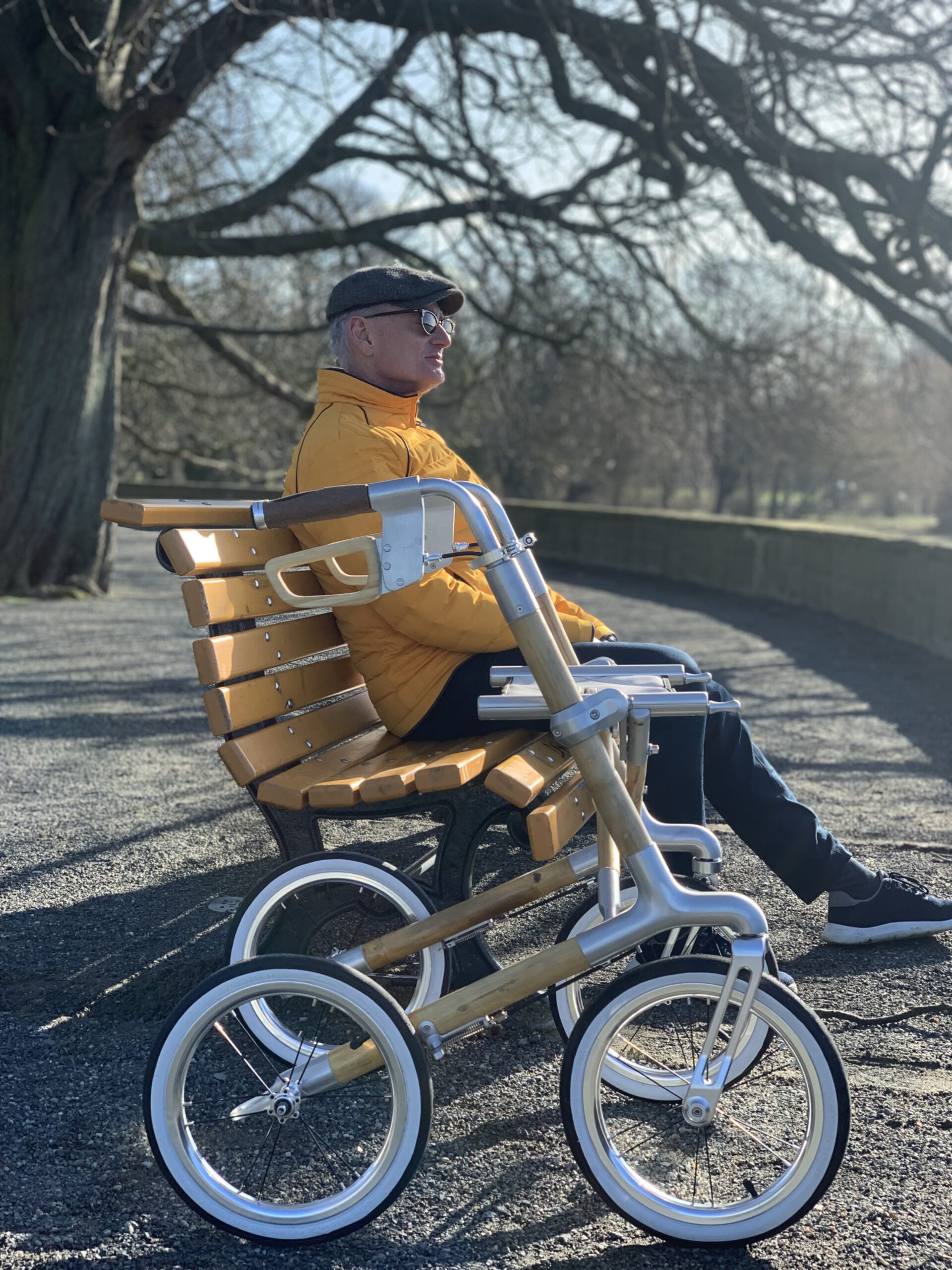 Mann, der auf einer Bank sitzt, neben ihm der Bambus-Rollator von andad'or